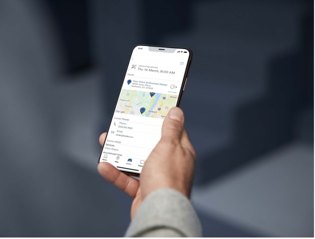 Persoon met telefoon in hand. Op de telefoon is de Volvo Cars app te zien.